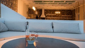 Una sala de estar moderna con una pared de piedra, una chimenea y un sofá con cojines.