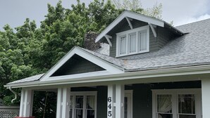A two-story house with a stone foundation, red steps, and a number 645 on the side. - Centrally located for all your activities! (Colville)