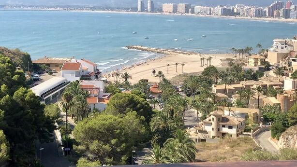 Une ville côtière avec une plage, des bâtiments et une vue sur la mer.