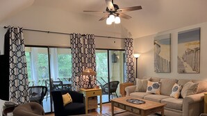 A living room with a sofa, armchairs, a coffee table, and a dining area with chairs and a table. - Short, pleasant walk to the beach! Two bedrooms, two baths. Dogs OK. (Kiawah Island)