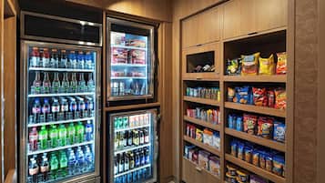 Un espace de vente proposant plusieurs distributeurs de boissons et des présentoirs de snacks.