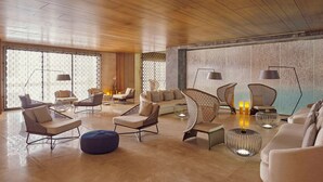 A spacious lounge area with modern seating, including sofas and chairs, and a large wall with a textured pattern. - Grand Hyatt Alkhobar Hotel and Residences (Al Khobar)