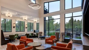 A spacious indoor area with large windows, multiple seating arrangements, and a flat-screen TV. - Residence Inn by Marriott Steamboat Springs (Steamboat Springs)