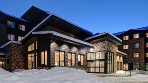 A modern multi-story building with large windows and a stone facade, surrounded by snow. - Residence Inn by Marriott Steamboat Springs (Steamboat Springs)