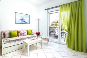 Relax in this stylish living room with a sofa, coffee table, and framed picture, plus a balcony with outdoor seating.