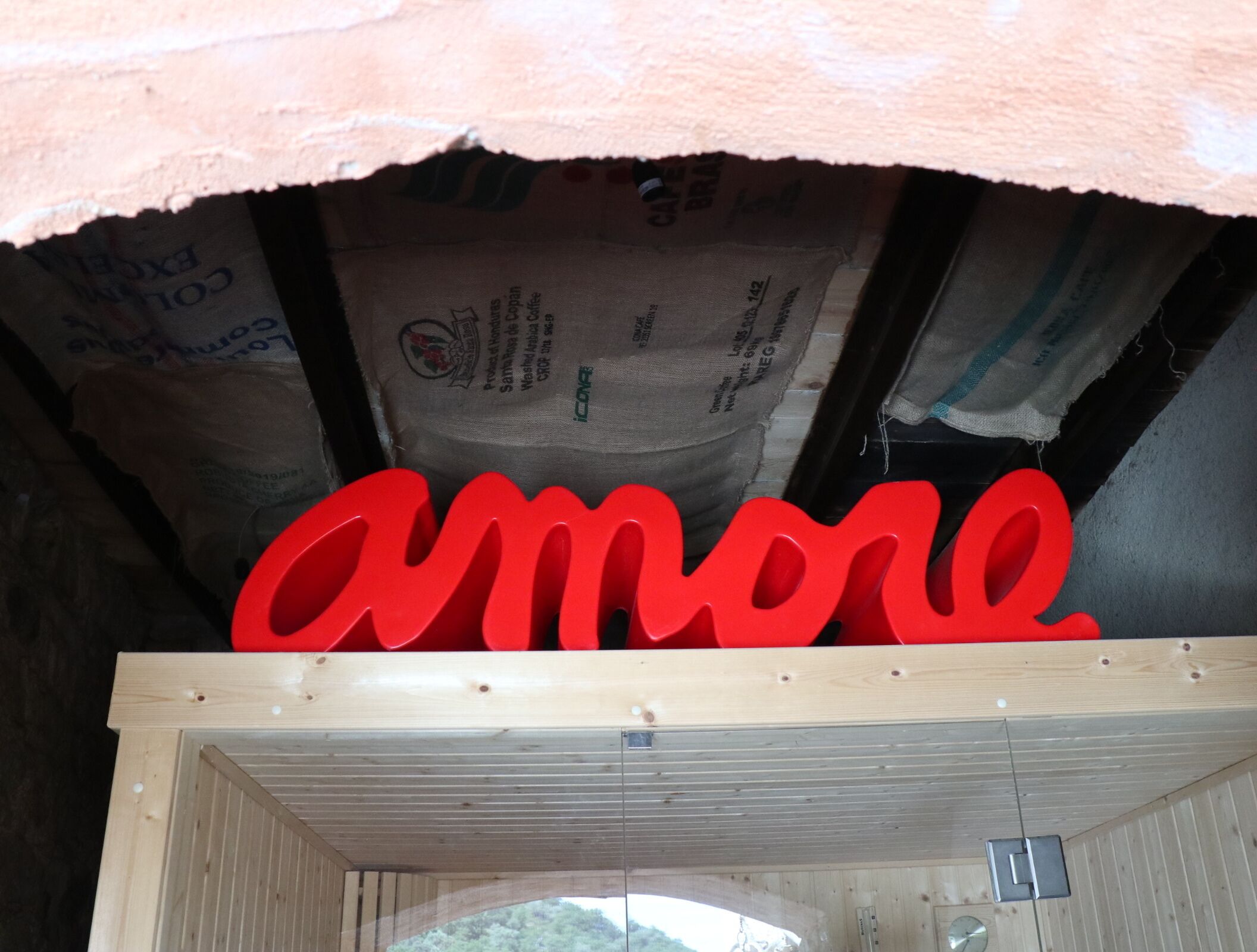 Una estructura de madera con un gran letrero rojo que dice 'amore'.