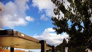 Una terraza de madera con dos jacuzzis, un muro de piedra y una valla de madera.