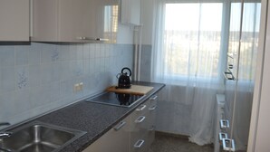 Cuina amb batedora, rentapelats i finestra amb cortines lleugeres.