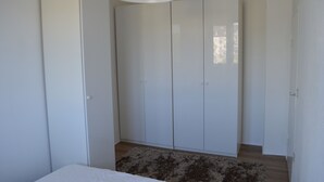 Un dormitori amb un armari gran, un llit i una làmpada penjant.