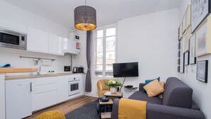 Un apartamento moderno con cocina, sala de estar y un amplio ventanal.