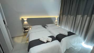 Una habitación de hotel con dos camas, un teléfono en la mesita de noche y una mesita de noche.