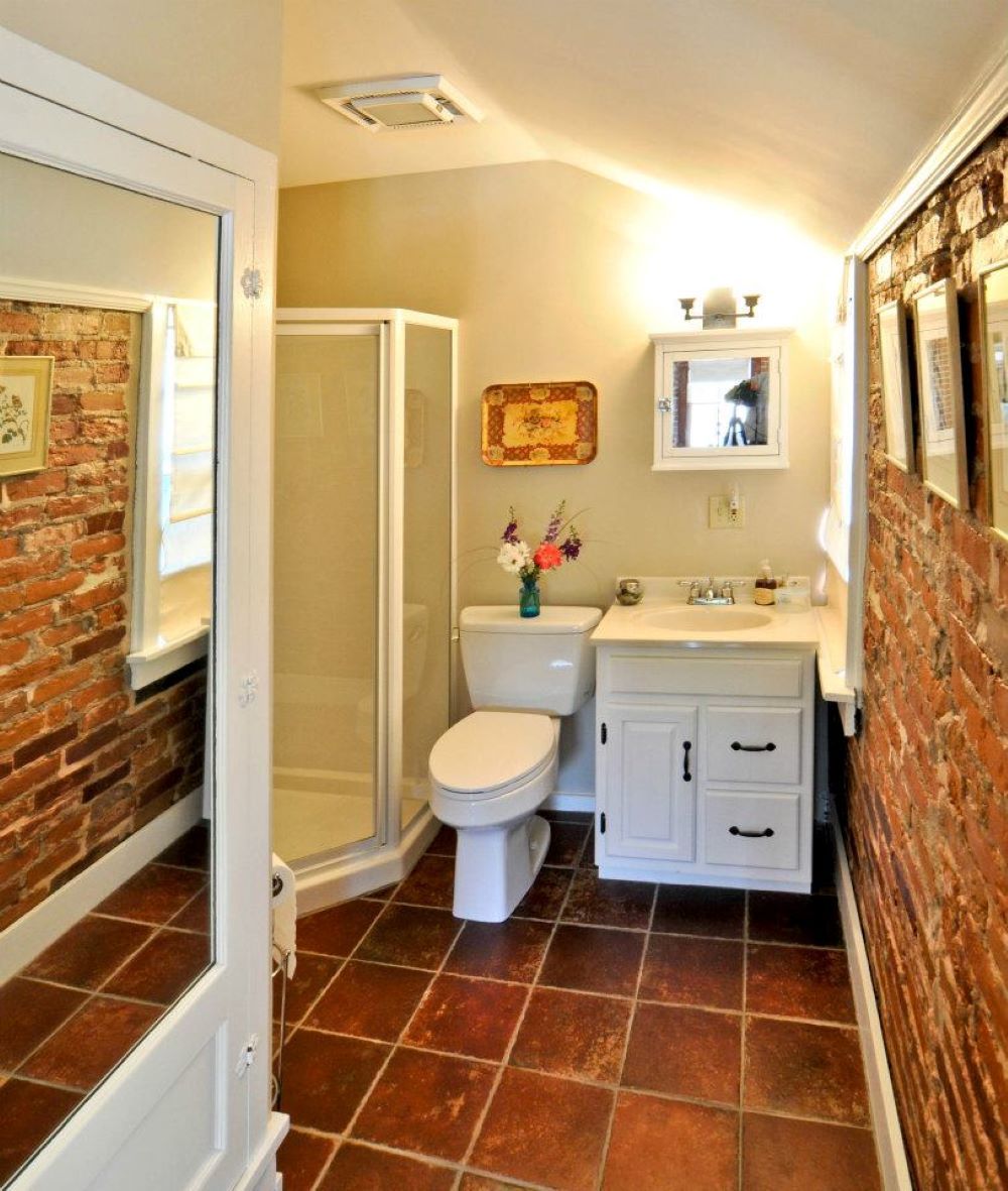 A compact bathroom with a toilet, sink, and shower.