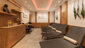 Un cuarto de spa con armarios de madera, un mostrador de recepción y sillones de descanso.