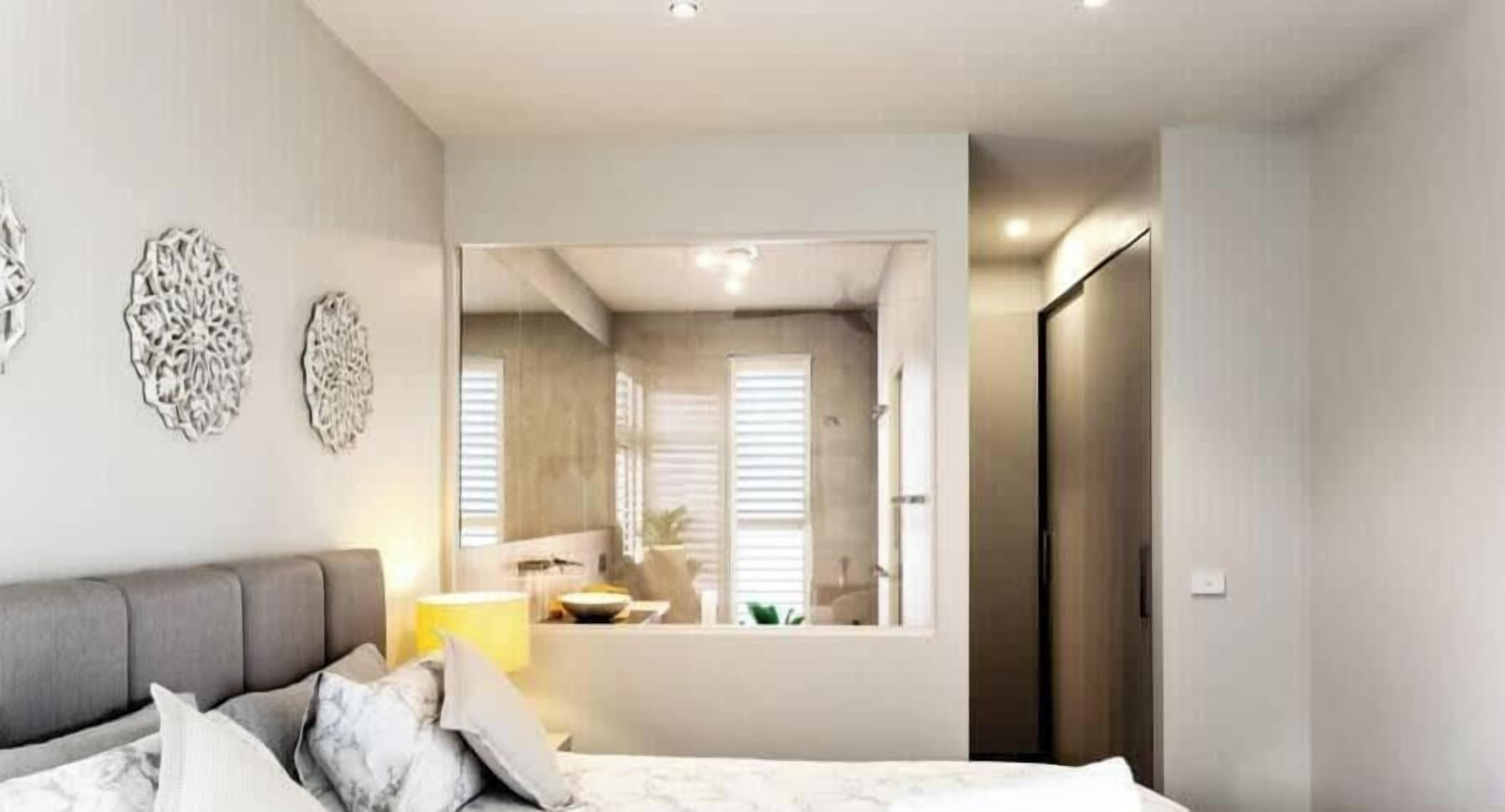 Une chambre moderne avec un lit, une table de chevet et des œuvres d’art décoratives au mur.