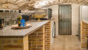 A kitchen with a granite countertop, a washing machine, and a vintage television. - Romantic, air-conditioned apartment in Paris in the heart of the historic Marais district (Paris)