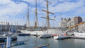 A harbor with multiple boats docked, including a large sailing ship. - Beautiful apartment in Oostende (Oostende)