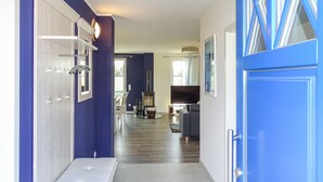 Ein Flur mit einer blauen Tür, einer Bank und einem Kamin.