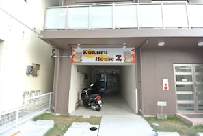 Welcome to Kukuru House 2, where a secure entrance is flanked by a fence and a glass door.