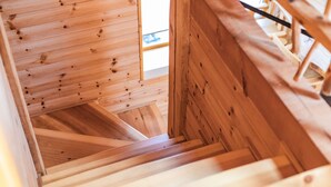A wooden staircase with a view of the upper floor. - Izu House Luxury Log with Cozy Fireplace (Ito)