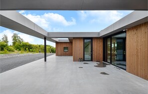 Contemporary building with a minimalist design, featuring a flat roof and a spacious outdoor area.