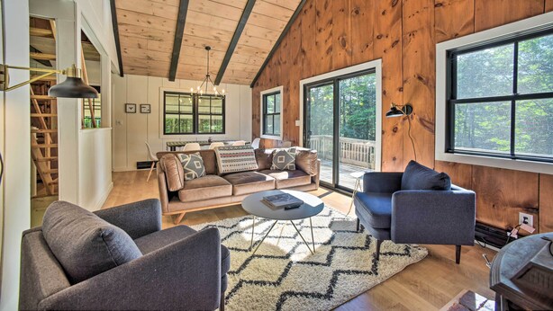 A spacious living room with a wooden ceiling, large windows, and a cozy seating area. - Sleek Cabin w/ Deck, 8 Miles to Mount Snow & Hikes (Wilmington)
