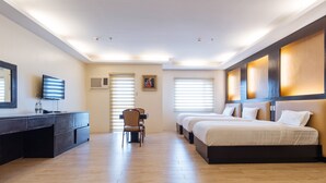 A hotel room with a desk, two beds, a chair, and a TV. - Northpointe Residences (Quezon City)