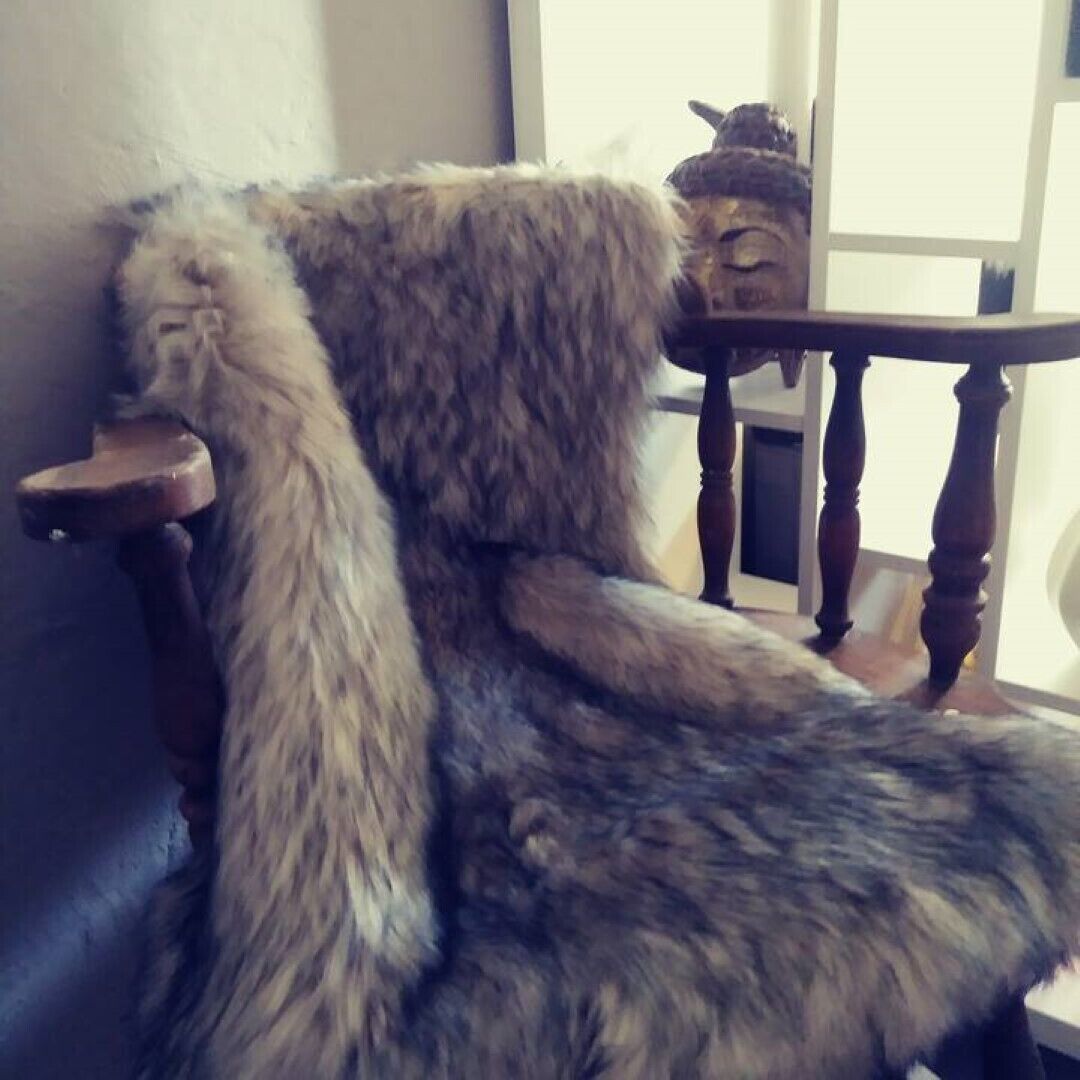 A chair with a fur-like cover and a wooden armrest.