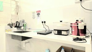 A kitchen with a sink, countertop, and various appliances including a coffee maker and a rice cooker. - No33 Mandalay House near Gleneagles Island Northern Heart Loh Guan Lye Hospital (George Town)