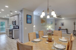 Enjoy meals in this stylish dining area with a table for four, kitchen, and elegant decor.