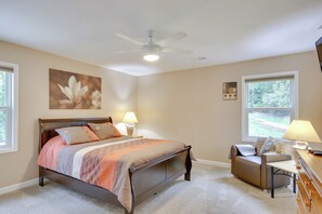 Enjoy a comfortable stay in this room featuring a modern bed, a cozy seating area, and a ceiling fan.