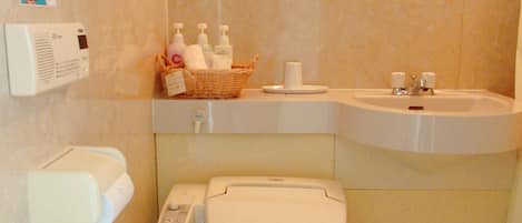 Un baño con inodoro, lavamanos, espejo y cortina de ducha.
