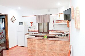 Kitchen features a central island, gas stove, sink, and refrigerator.