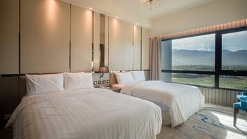 A hotel room with two beds, a large window with a view of mountains, a chandelier, and a modern design.