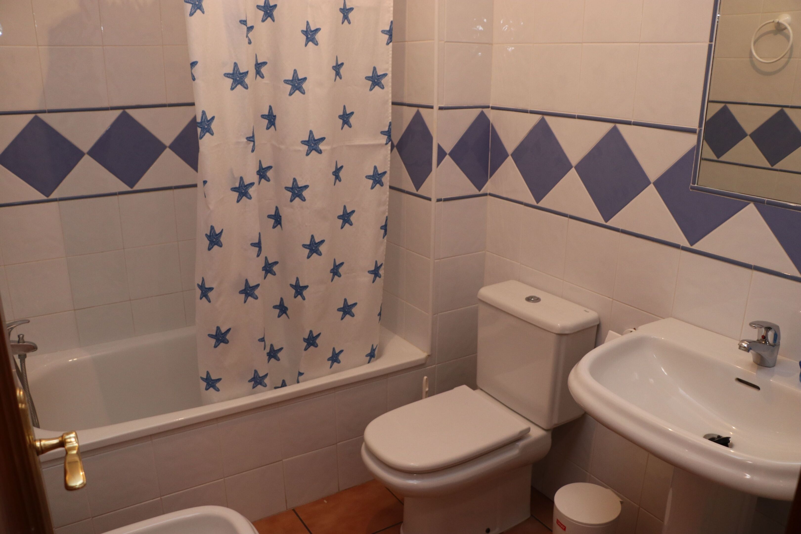 A bathroom with a bathtub, toilet, and sink.