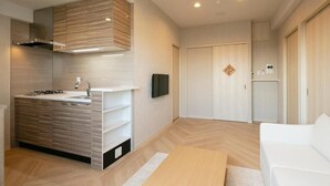 Una cocina moderna con estufa integrada, televisor de pantalla plana y un mueble de madera.