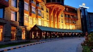 A hotel with a modern architectural design, featuring a prominent curved structure and multiple balconies. - Pearl Continental Hotel Malam Jabba (Swat)