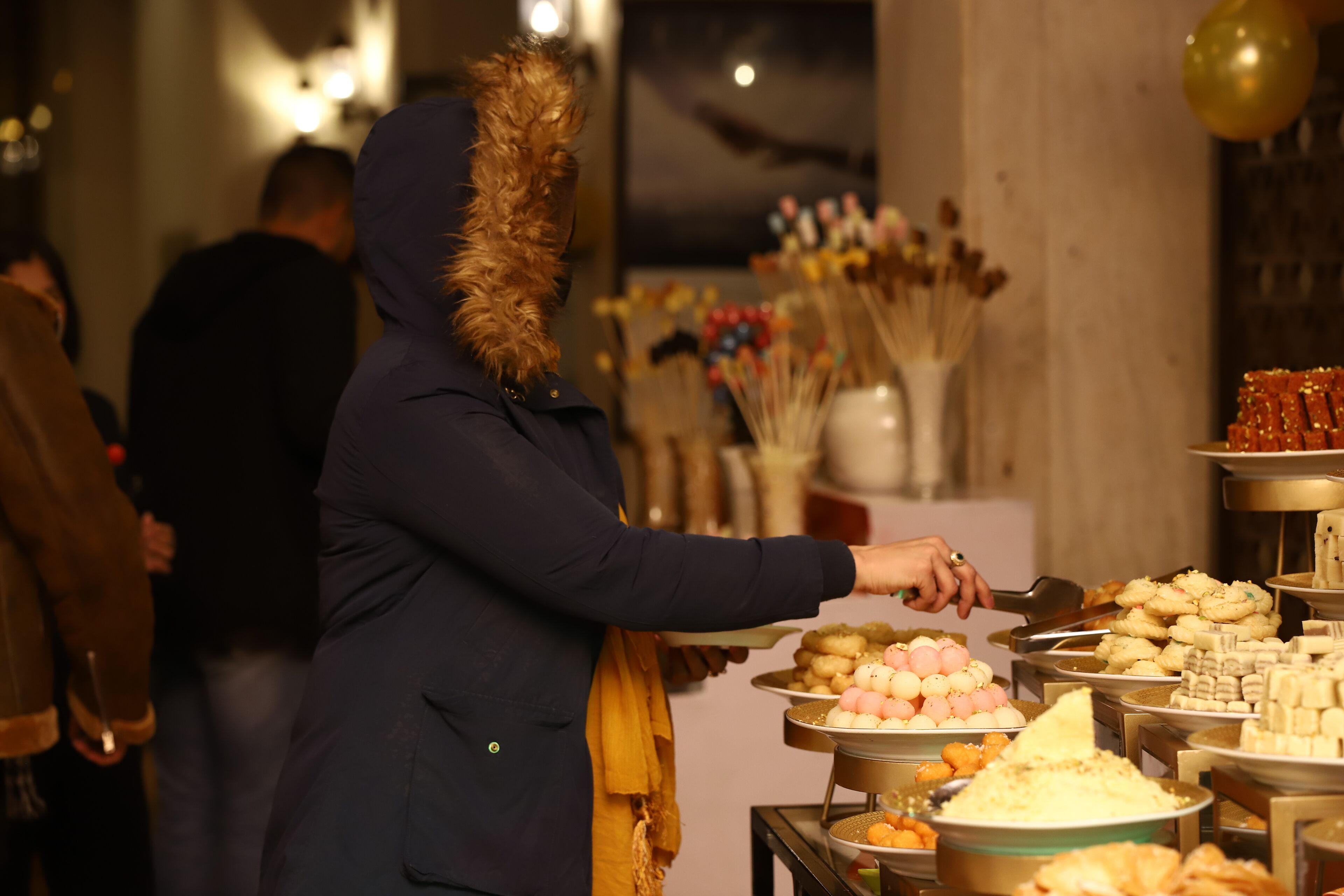 Un buffet con diversi piatti e una persona che serve.