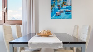 A dining table with a white tablecloth, two white chairs, and a plate with eggs. - Holiday Home “El Rafal de Son Alberti” with Mountain View, Air Conditioning and Pool (Buger)