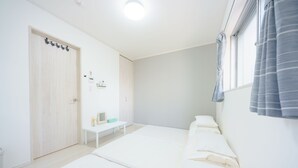 A minimalist bedroom with a bed, bedside table, and a wardrobe. - osaka yeon house (Osaka)