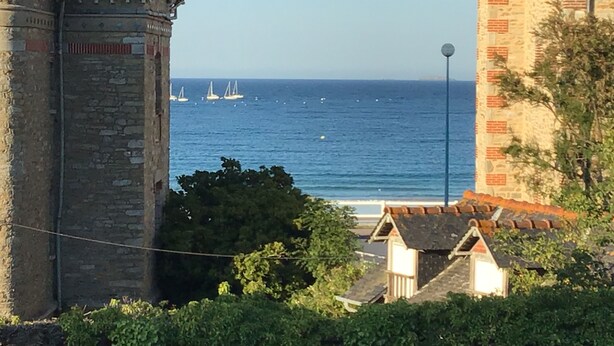 A coastal view with a stone tower and a building with a red roof. - Duplex apartment with sea view (Saint-Cast-le-Guildo)