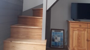 A staircase with wooden steps and white railings, leading to a lower level. - Duplex apartment with sea view (Saint-Cast-le-Guildo)