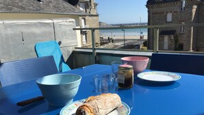A table with a baguette, a bowl, a glass, and a jar of jam. - Duplex apartment with sea view (Saint-Cast-le-Guildo)