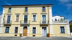 Un bâtiment à deux étages doté d’une entrée centrale, de balcons et d’une façade décorative.