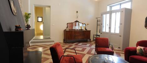 A living room with a red sofa, a round coffee table, and a wooden cabinet.