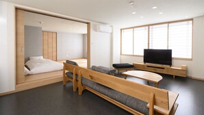 Una habitación moderna con una cama, un televisor y un rincón de descanso.