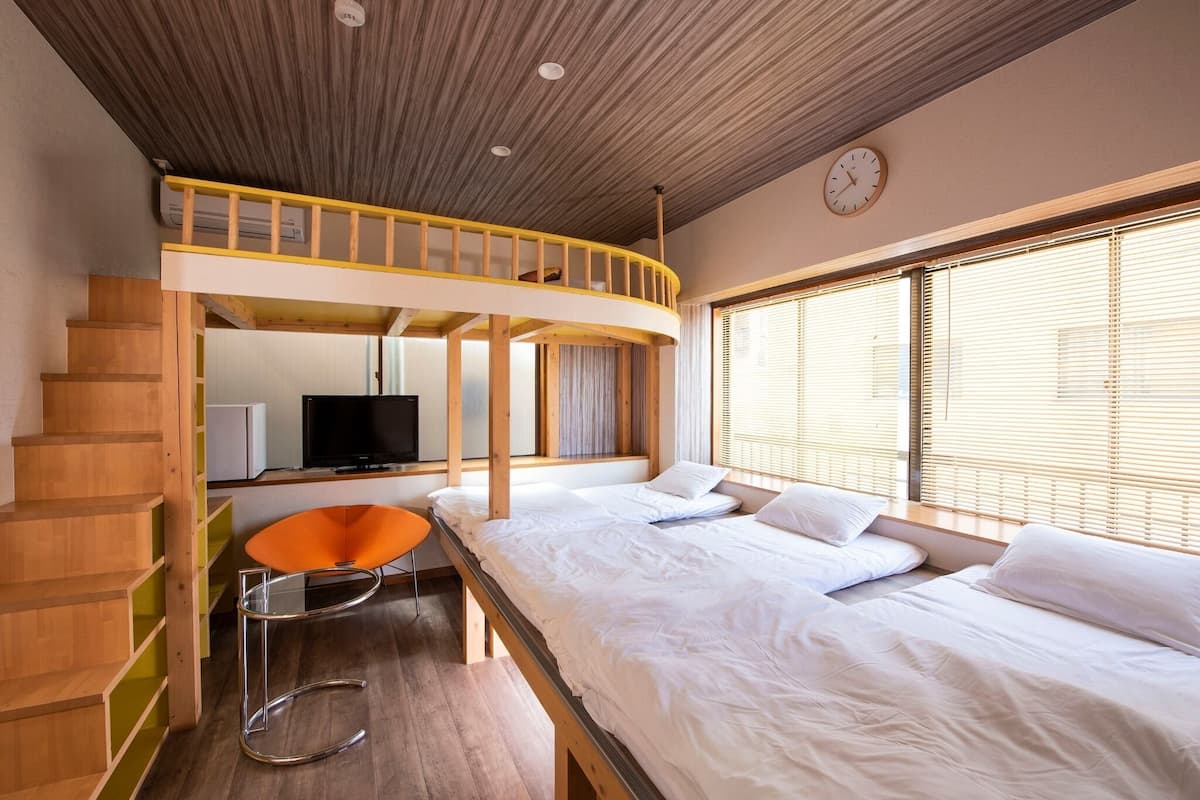 A room with a bunk bed, a desk, and a TV.