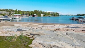 A lakeside view with boats, a dock, and buildings along the shore.