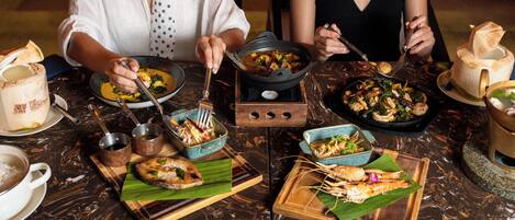 Una mesa de comedor con diferentes platos, cubiertos y una vela.