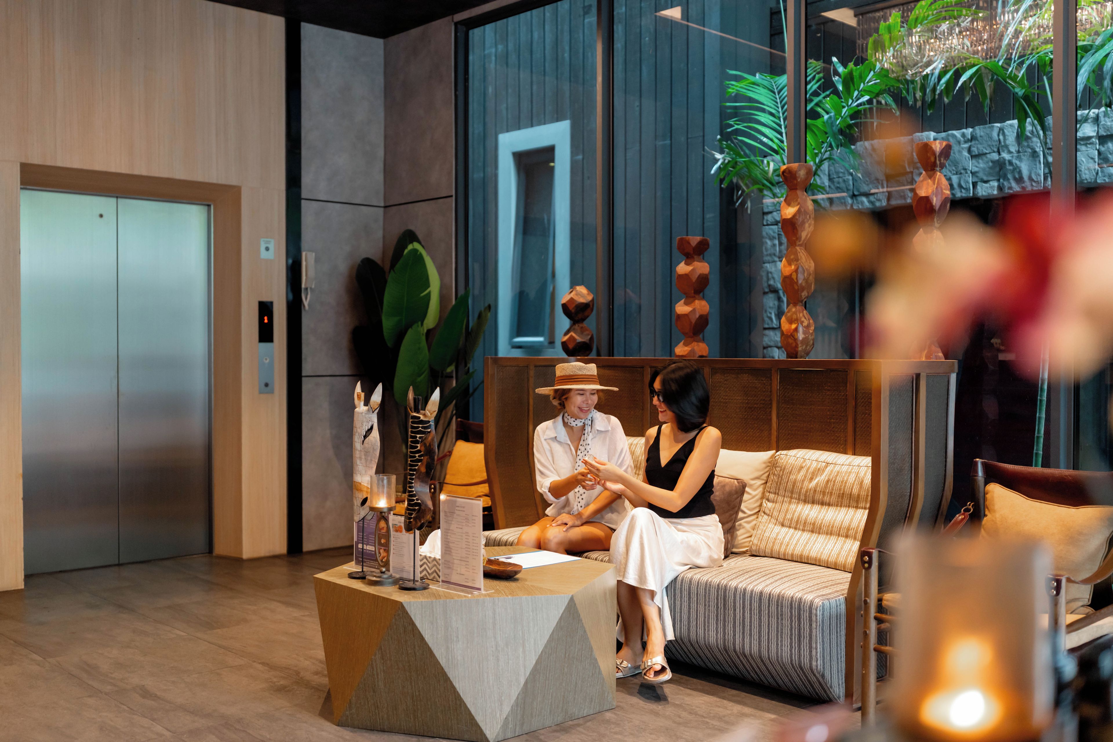A reception area with a reception desk, seating area, and a large window with a view of greenery.