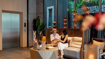A reception area with a reception desk, seating area, and a large window with a view of greenery.